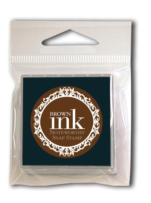 Compact plastic package with a brown “Brown Snap Stamper Ink Pad Refill” by Noteworthy, featuring a decorative circular front—ideal for clean, quick snap stamp impressions.