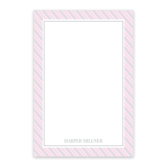 The Noteworthy Pink Pinstripe Personalized Notepad features pink and white diagonal stripes, a blank center, "Harper Millner" printed at the bottom, and comes with 50 sheets per pad.