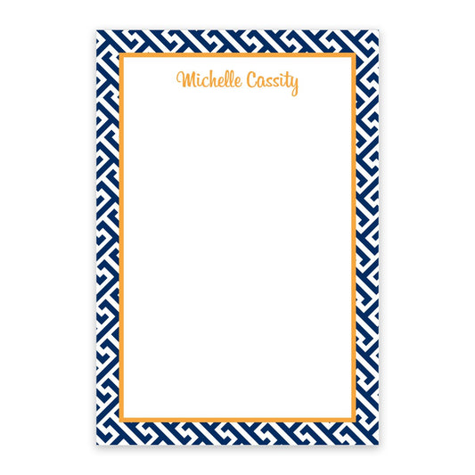 The Noteworthy Navy Geometric Pattern Personalized Notepad features a white center, blue geometric border, orange inner border, and "Michelle Cassity" at the top in orange script.
