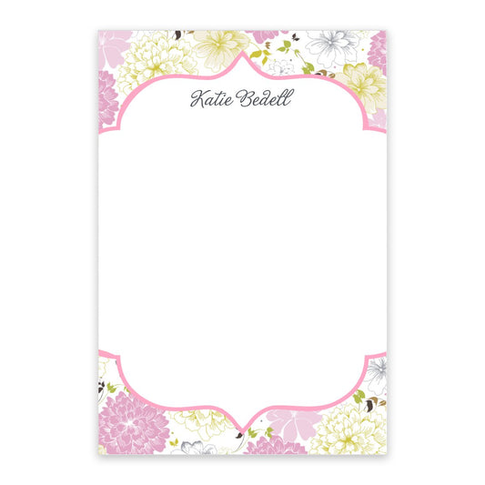The Pink Bouquet Personalized Notepad by Noteworthy features elegant cursive "Katie Bedell" at the top and is bordered with pink, white, and yellow floral blooms.