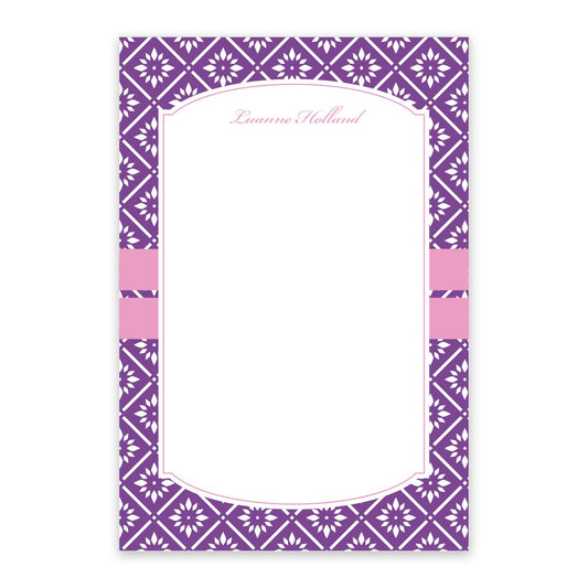 The Noteworthy Purple Banded Personalized Notepad features a rectangular purple floral design, white diamond border, two pink bands, and "Luanne Holland" in pink cursive. Includes 100 sheets to add charm to your notes.