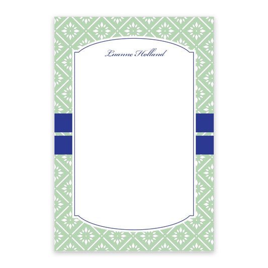 The Noteworthy Mint Banded Personalized Notepad features a rectangular shape with a green and white geometric border, blue accent stripes, and “Luanne Holland” at the top. The center is blank for your notes.