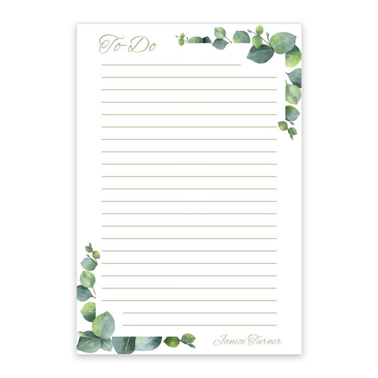 The Noteworthy Ivy Frame Notepad offers 100 blank, lined sheets with green watercolor leaf accents and "Janice Turner" personalized at the bottom right, creating a charming floral design.