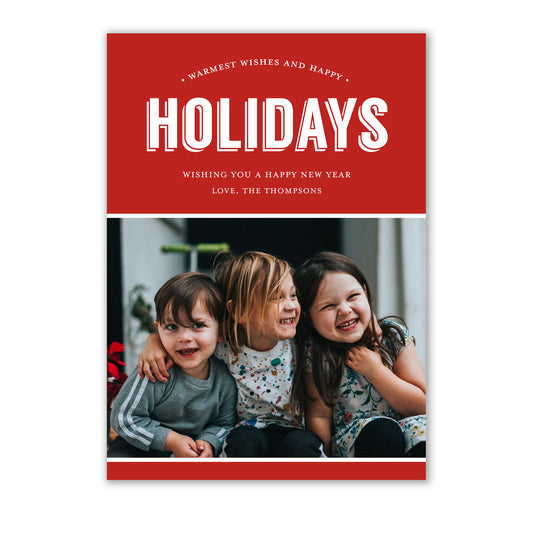A group of children sitting together, ready to pose for their holiday photo card. They hold delicate white unlined envelopes, brought to them by Noteworthy Collections's Elegant Red Holiday Photo Cards.