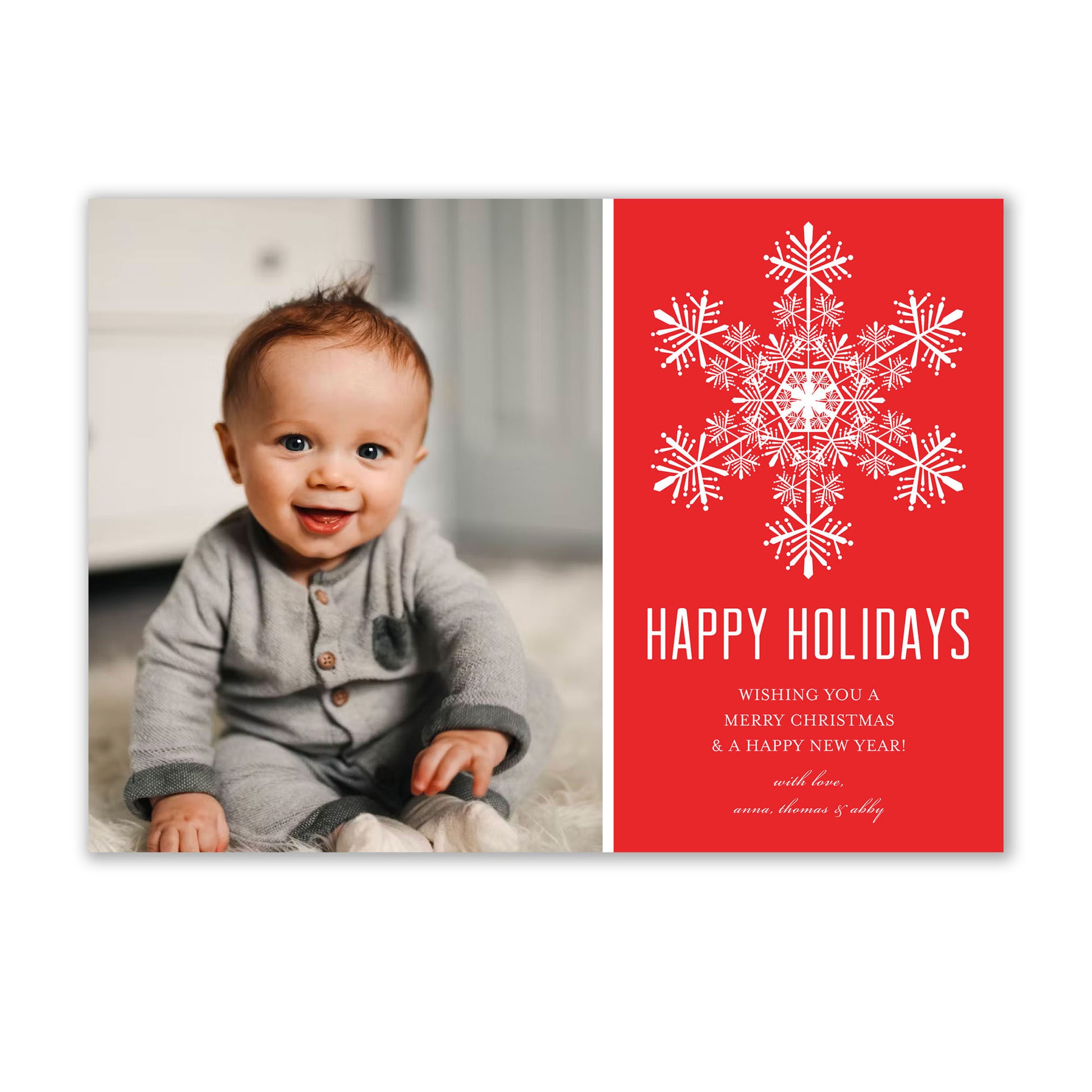 An Elegant Snowflake Holiday Photo Cards baby sitting on the floor. (Brand Name: Noteworthy)