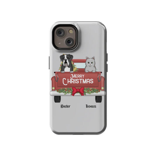 The InvitationBox.com Custom Merry Christmas Pets in Truck iPhone 14 Tough Case features a dog and cat in a red truck with "Merry Christmas" sign; personalize with pets and names like "Buster" and "Toonces" printed below.