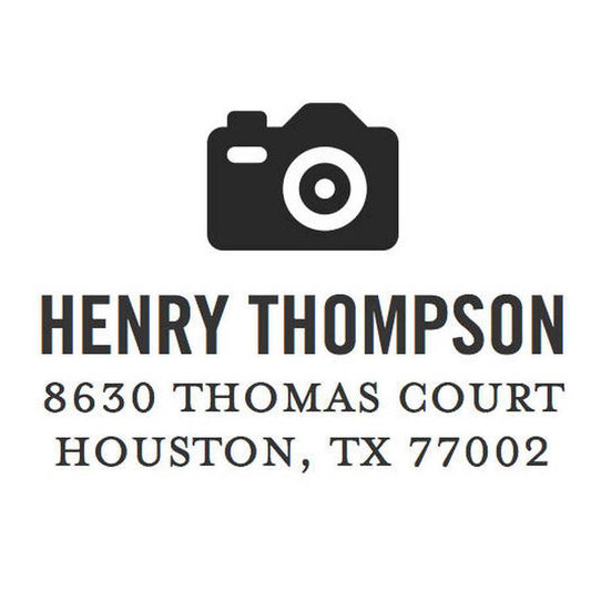 The Modern Camera Stamper or Embosser by Noteworthy features a black camera icon above the text "Henry Thompson, 8630 Thomas Court, Houston, TX 77002" on a white background—ideal for stylish personalized stamps.
