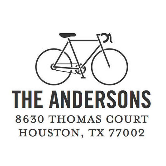 A black outline of a road bike appears above "The Andersons, 8630 Thomas Court, Houston, TX 77002" on white—ideal for the Noteworthy Skinny Bike Stamper or Embosser.
